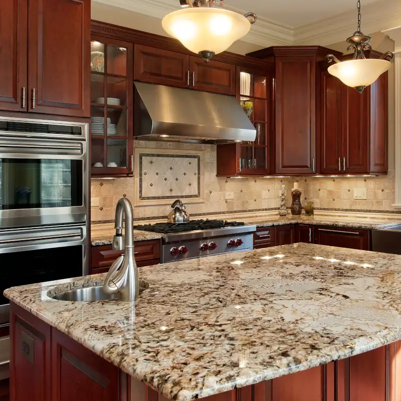Luxury kitchen with dark wood cabinets, granite island, stainless steel appliances, Simone faucet, and pendant lighting.