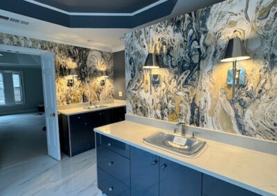 Luxurious bathroom with marble backsplash, dark cabinets, modern lighting, sleek sink, and white-tiled floor design. - Milton GA by Simone Feldman Designs