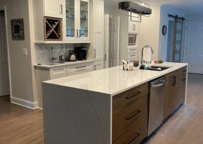 Modern kitchen with white cabinets, wood island, marble countertop, wine rack, stainless steel appliances, and pendant lighting - Roswell GA by Simone Feldman Designs